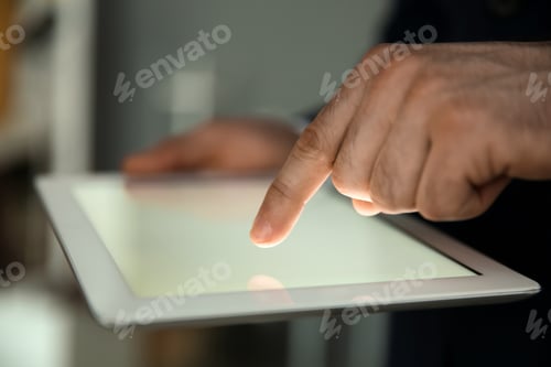 Preview: Businessman using digital tablet at workplace, closeup of hand. Mockup for design