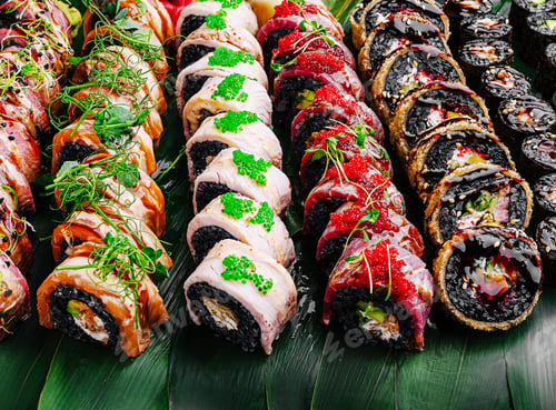 Preview: Sushi rolls arranged beautifully on a green leaf platter