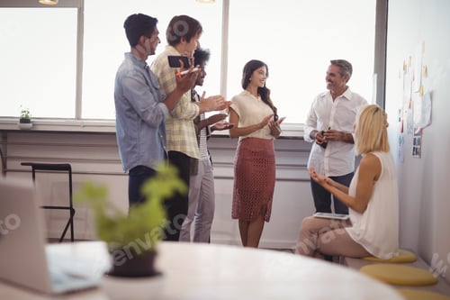 Preview: Business people discussing strategies in creative office