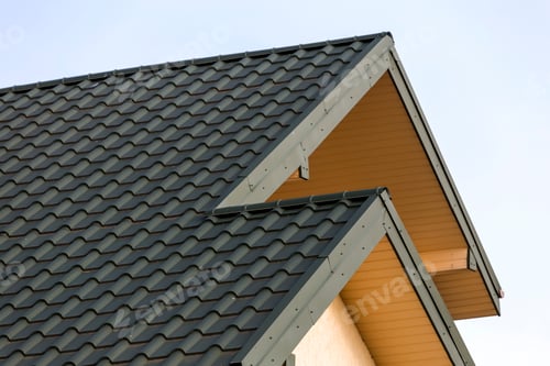 Preview: Close-up detail of new modern house top with shingled green roof on clear blue sky background