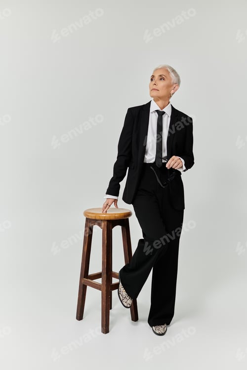 Preview: Elegant Attire on a Mature Woman Posing Thoughtfully in a Chic Studio Setting