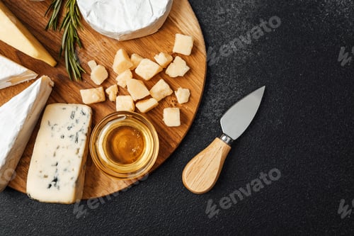 Preview: Cheese platter featuring various types and honey on a wooden board