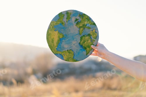 Preview: Woman holding planet in hands against green spring background