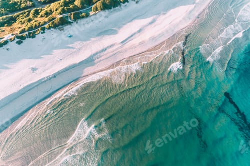 Preview: shore of a turquoise water beach at sunrise as seen from a drone