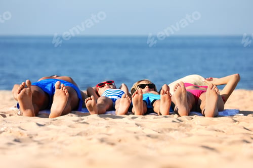 Preview: Family lying on sandy beach near sea. Summer holidays