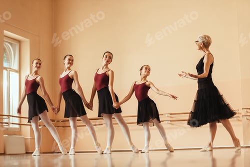Preview: Happy ballerinas practicing choreography with their ballet instructor at dance studio.