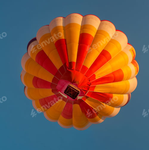 Preview: Bright yellow-red hot air balloon in the blue sky