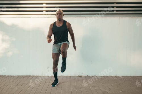 Preview: African American man doing fitness warm-up exercise outdoors