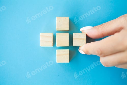 Preview: Hand arranging wood block with empty space.