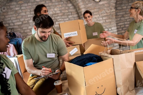 Preview: Group of volunteers with working in community charity donation center.
