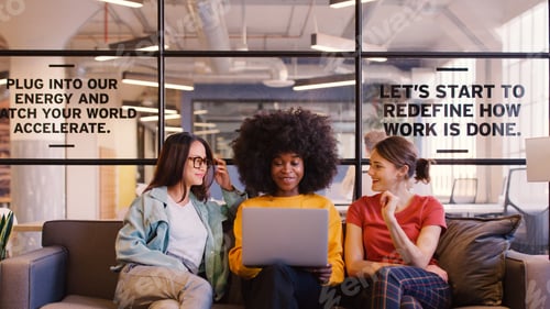 Preview: Three Young Businesswomen Working On Laptop In Informal Seating Area Of Modern Office