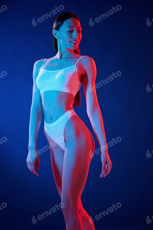 Preview: White top. Young woman in underwear is in the studio with neon lights