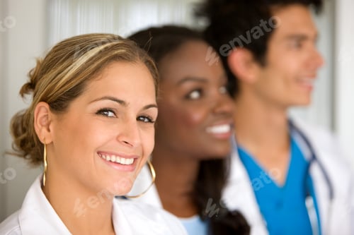 Preview: Group Of Doctors In A Hospital Smiling - Woman Leading