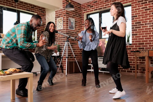 Preview: Young adult people enjoying disco music at home while celebrating friendship anniversary event