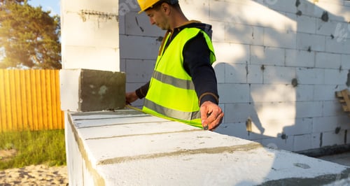 Preview: Construction worker at construction site measures the length of the window opening