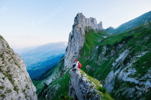 Preview: Tourist on the high rocks background. Sport and active life concept. Adventure and travel