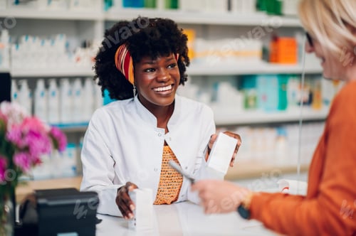 Preview: Smiling african american woman pharmacist working in a pharmacy