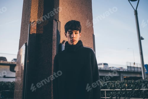 Preview: Young man in contemplation against an urban backdrop