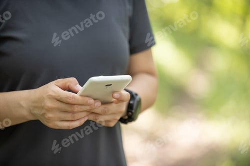 Preview: Hands using mobile phone in summer forest