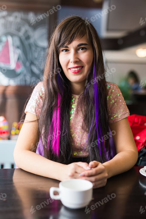 Preview: Young stylish trendy woman with multi-coloured strand in hair sits in cafe