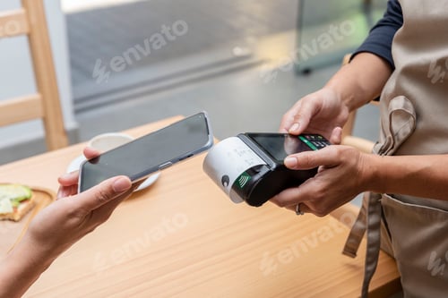 Preview: paying with a mobile app through a payment terminal in the hands of the waitress in a bar