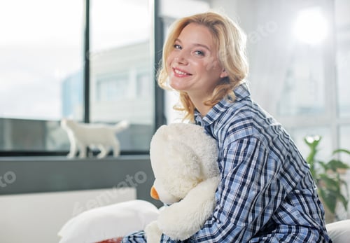 Preview: Joyful Woman Sitting And Holding Close Teddy Toy. She Is Looking At Camera With Smile. Copy Space
