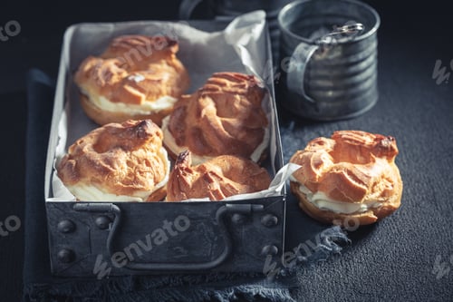 Preview: Sweet and hot cream puffs on rustic dark table