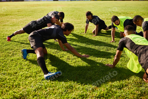 Preview: Cropped shot of a diverse group of sportsmen stretching before a rugby practice during the day