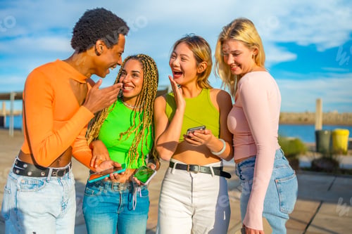 Preview: Surprised multi-ethnic friends using phone together outdoors