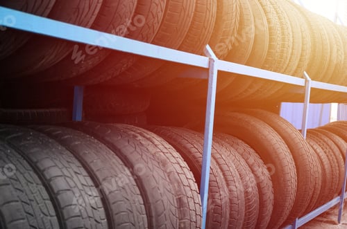 Preview: Rack with variety of car tires in automobile store. Many black tires. Tire stack background