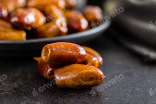 Preview: Dried dates fruit on black table.