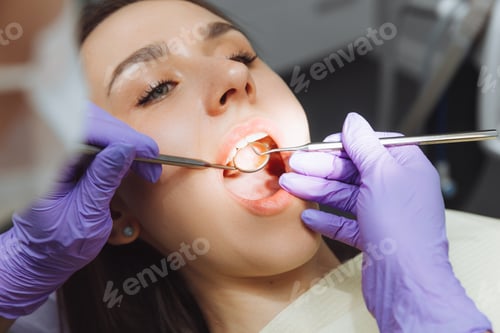 Preview: The dentist examines the teeth of a female patient, close-up. modern dentistry