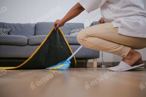 Preview: Unrecognized People Sweeping The Floor Under Carpet With A Broom At Home