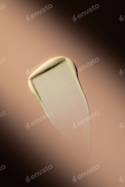 Preview: Swatch. A sample of a cream, cosmetic product on a pink background with a hard shadow.