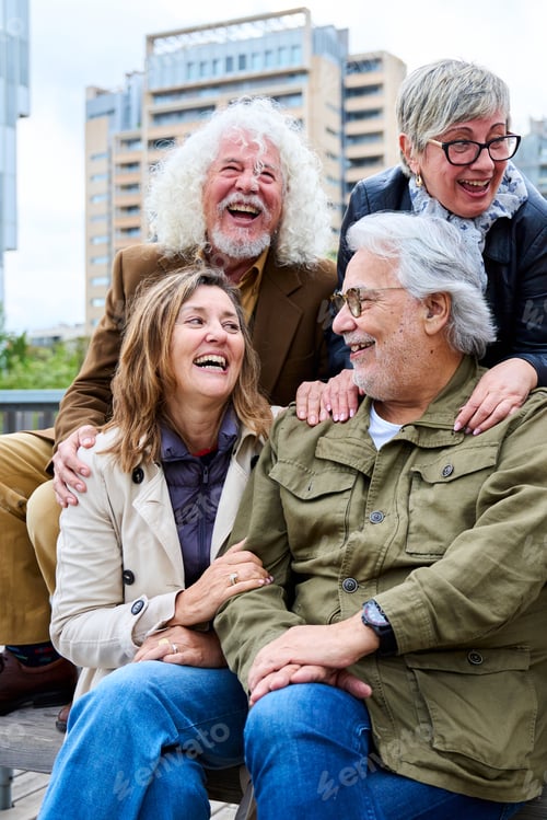 Preview: Group of elderly Caucasians friends people having fun laughing together sitting on bench in city.