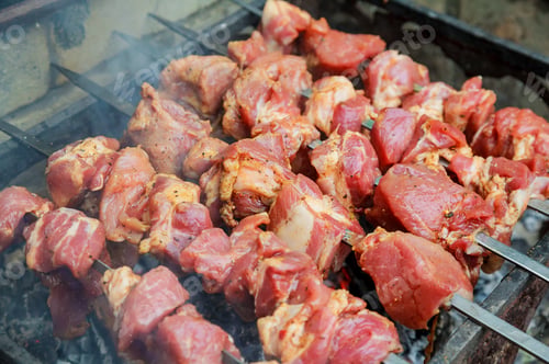 Preview: closeup of some meat skewers being grilled in a barbecue