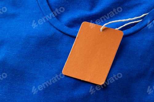 Preview: Close up of blue tshirt with red tag and copy space