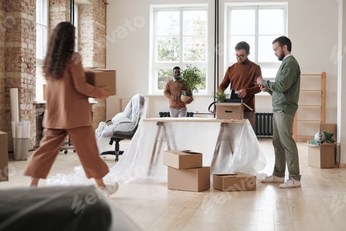 Preview: Group of colleagues unpacking stuff in new office