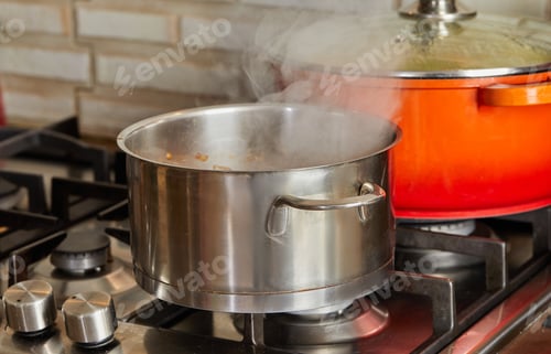 Preview: Pots with steam boiling on gas stove in the kitchen
