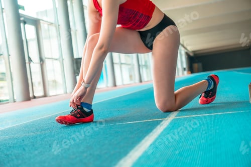 Preview: Indoor athletics, sprinter woman preparing shoes for training