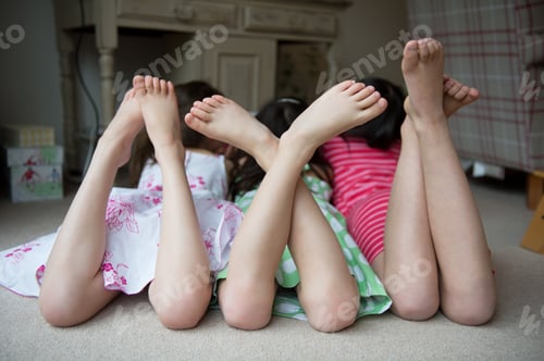 Preview: Girls lying on floor together with feet up