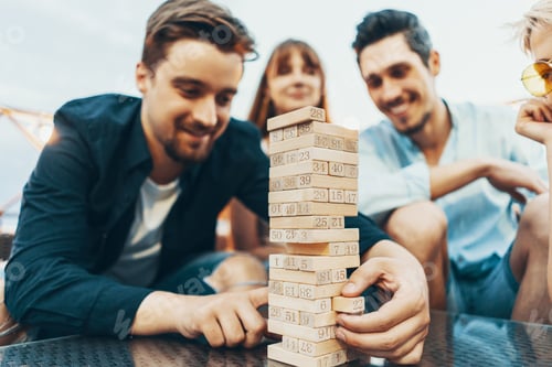 Friends Enjoying a Game of Tower Building Outdoors