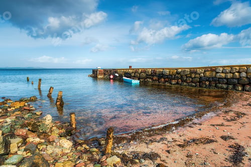 Preview: A small boat moored at an old stone jetty at Sannox