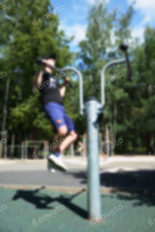 Preview: Sport- Training Outdoors In Summer Park. Workout Young Man Performs Exercise. Blurred Background