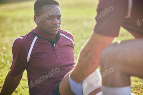 Preview: First aid, sport injury and black man with soccer accident, fitness and massage on a field. Trainin