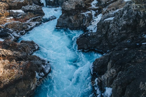 Preview: beautiful rapid stream with cold water and rocks in iceland, Hraunfossar