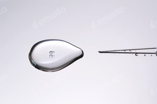 Preview: A drop of medicine flowing from a syringe with a needle.