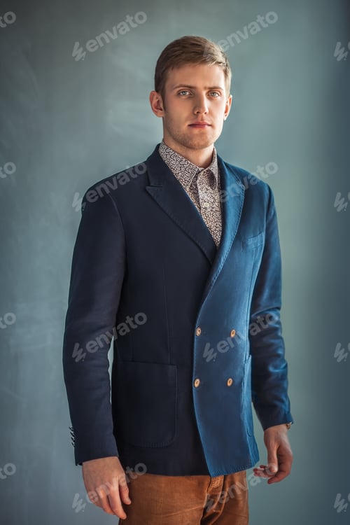 Preview: Portrait of handsome man standing against grey wall