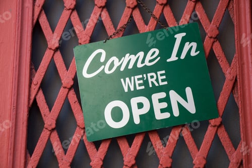 Preview: Green Come In We are Open sign hanging from a metal door