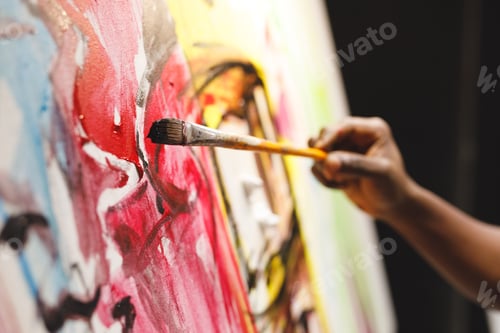 Preview: Close up of african american male painter at work painting on canvas in art studio